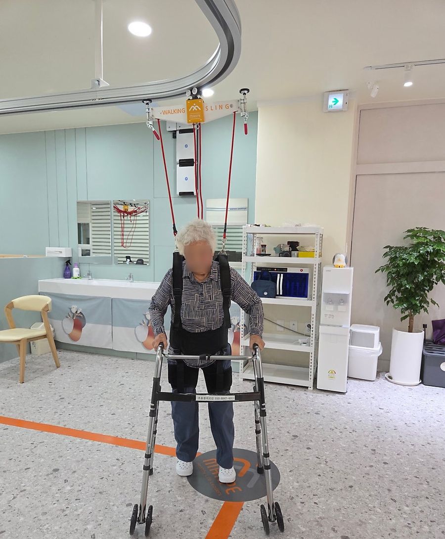 보행기를 잡고 보행 라인을 따라 걷는 어르신